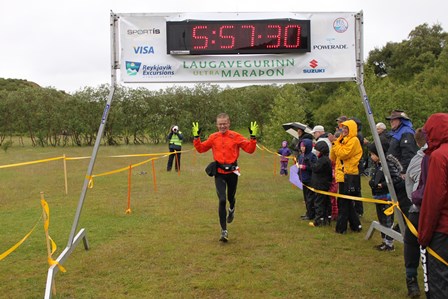 Síðustu skrefin, 3 sek. eftir í mark. (Klukkan á myndinni er 5 mín. of fljót, því að hún tók tímann á „gula hópnum“. Hér ríkir gleðin ein. (Ljósm. Hlaup.is (birt með leyfi)).